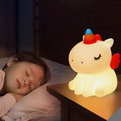 Enfant endormit a cote de sa veilleuse licorne illuminant